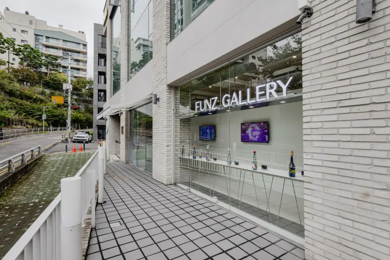 화이트 벽돌과 유리로 완성한 모던 NFT 갤러리